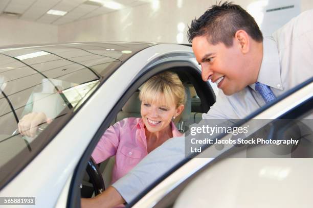 salesman showing car to woman in dealership - sells arizona 個照片及圖片檔