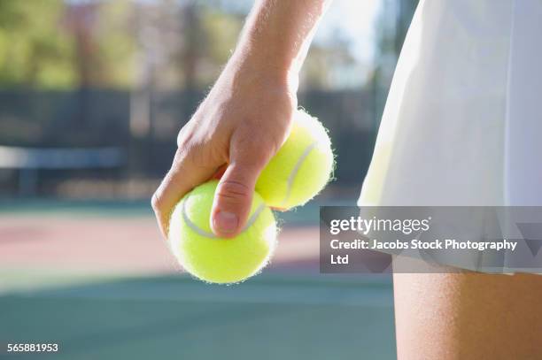 caucasian woman holding two tennis balls - holding two things foto e immagini stock