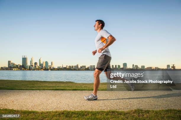 caucasian man running near urban waterfront, perth, western australia, australia - waterfront park stock pictures, royalty-free photos & images