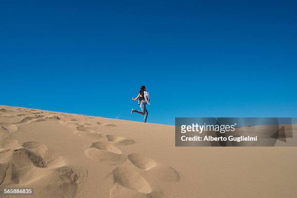 caucasian woman running on sand dune - agadir - fotografias e filmes do acervo