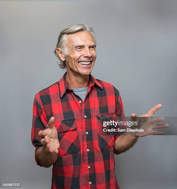 smiling older caucasian man gesturing - kariertes hemd stock-fotos und bilder