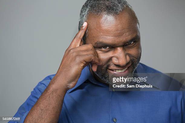 older african american man tapping his forehead - tap forehead stock pictures, royalty-free photos & images