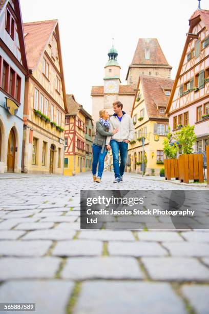 caucasian couple walking in city - rothenburg stock pictures, royalty-free photos & images