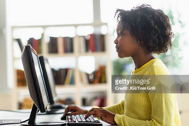 black student using computer in classroom - black girl with computer stock-fotos und bilder