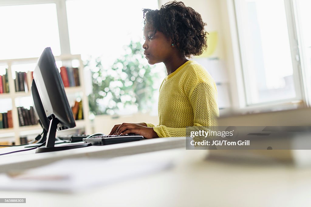 Black student using computer in classroom