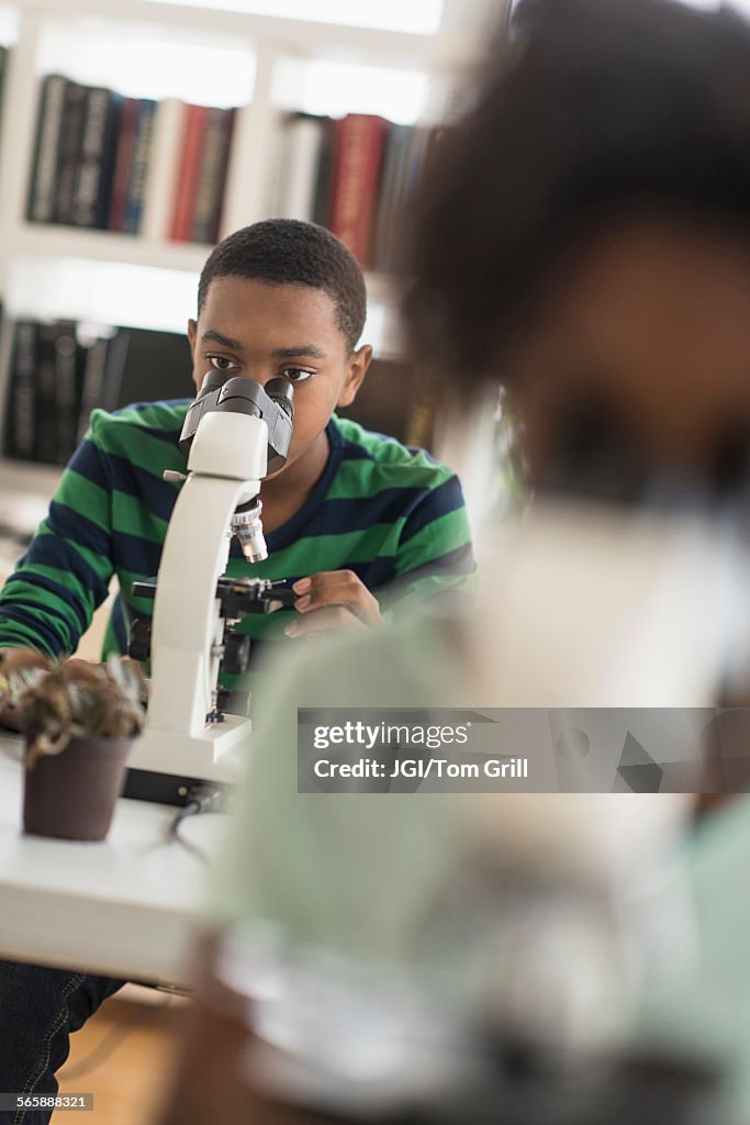 Black Using Microscope Black Students Using Microscopes In Science Lab Photo - Getty Images