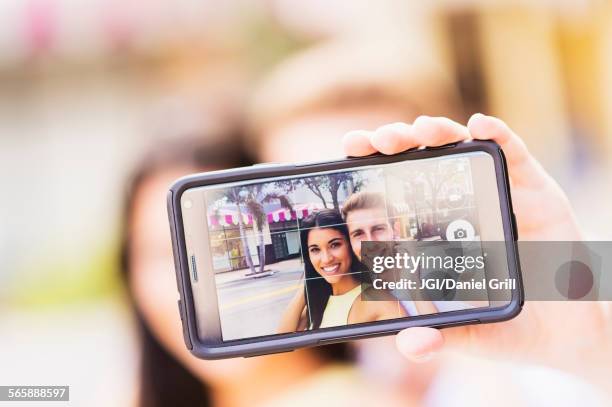 close up of hispanic couple taking selfie outdoors - digitalkamera bildschirm stock-fotos und bilder