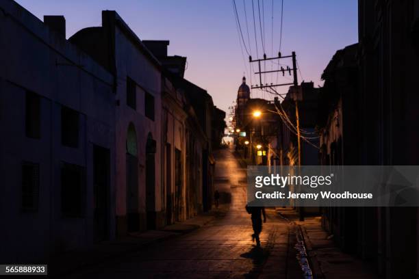 pedestrian walking on santiago de cuba street at night, santiago, cuba - cuba night stock pictures, royalty-free photos & images