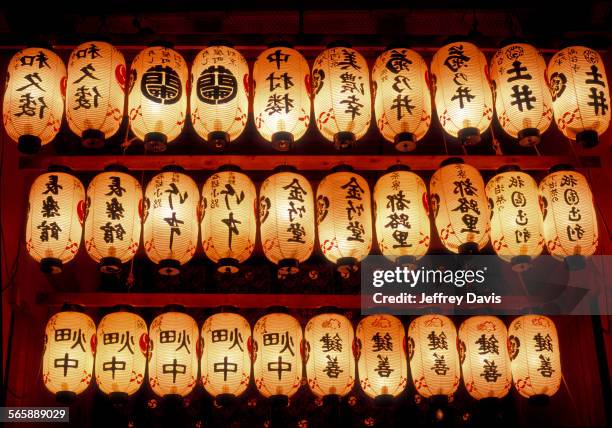 rows of illuminated prayer lanterns at night - linterna de papel fotografías e imágenes de stock