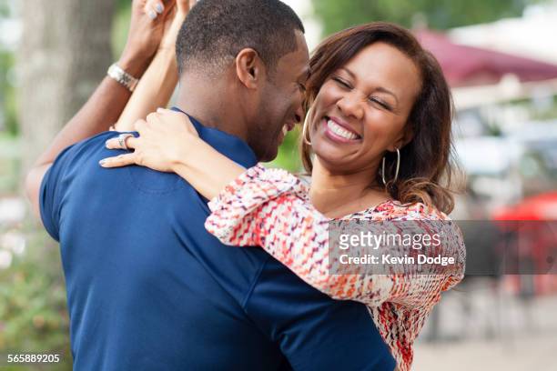 smiling couple dancing on sidewalk - couple dance stock pictures, royalty-free photos & images