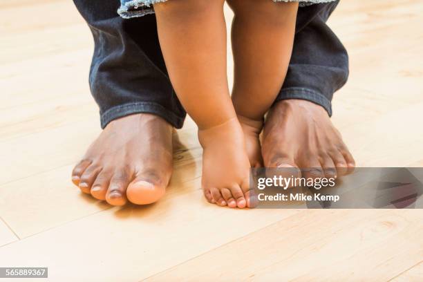 close up of feet of black father and baby son - black men feet stock-fotos und bilder