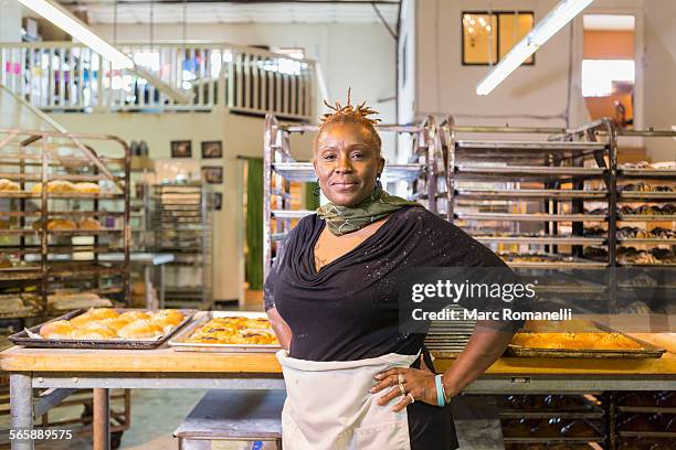 black baker standing in bakery kitchen - bakery apron stock pictures, royalty-free photos & images