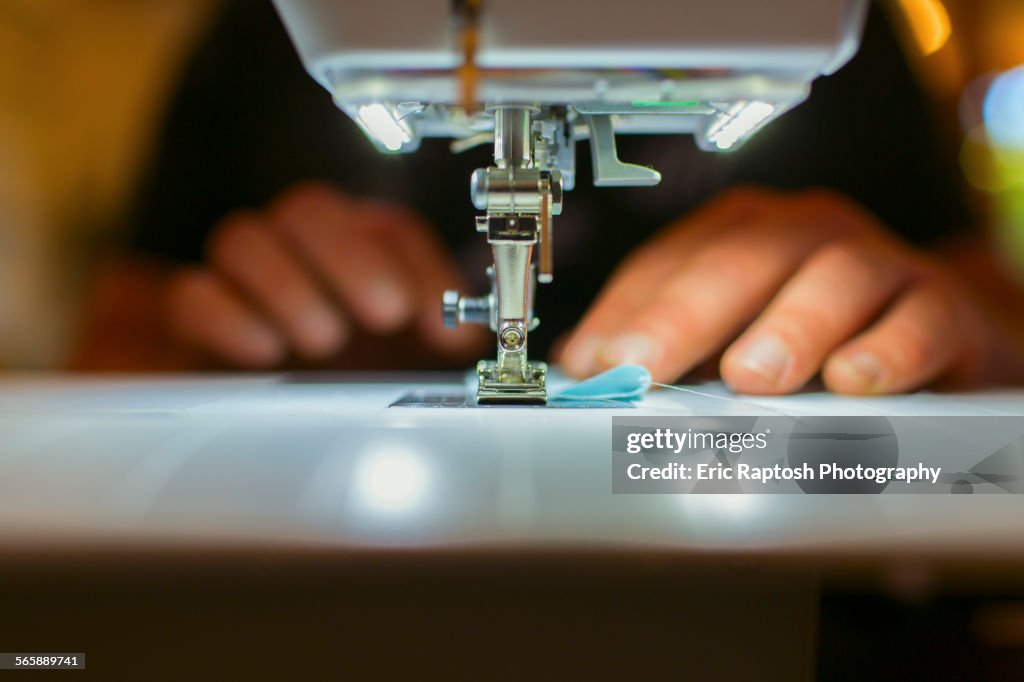 Close up of Caucasian dressmaker using sewing machine