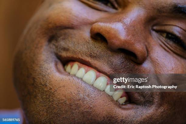 close up of black man smiling - op de lip bijten stockfoto's en -beelden