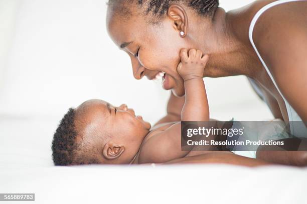 black mother and baby playing on bed - black baby 個照片及圖片檔