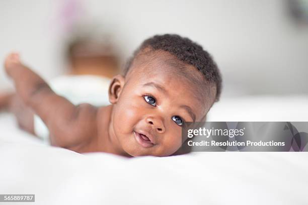 close up of black baby laying on bed - bebês meninos - fotografias e filmes do acervo