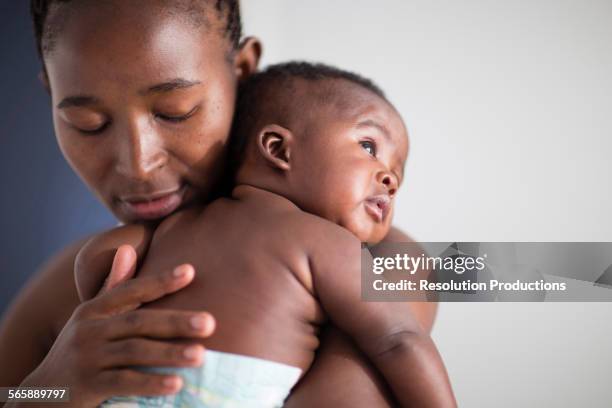 close up of black mother holding baby - black baby 個照片及圖片檔