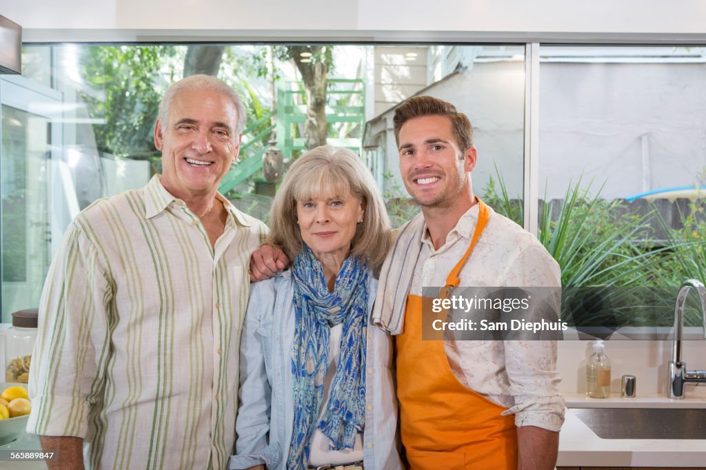 Caucasian parents and son smiling in kitchen