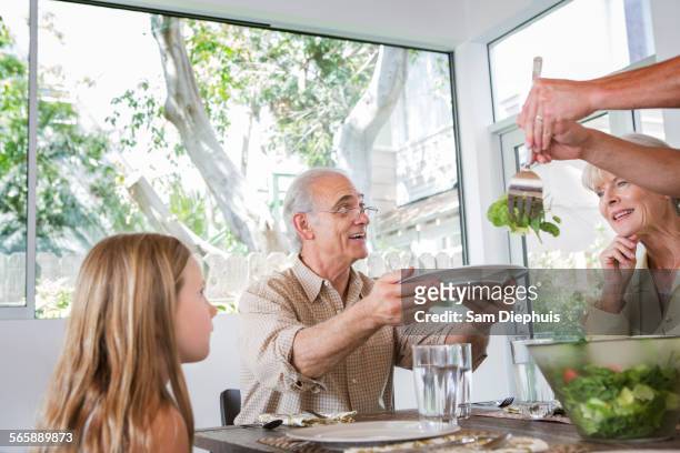 caucasian multi-generation family eating at table - wellness kindness love stock pictures, royalty-free photos & images