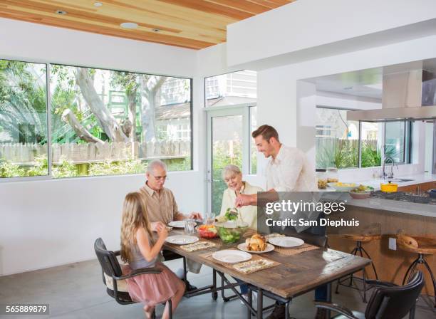 caucasian multi-generation family eating at table - wellness kindness love stock pictures, royalty-free photos & images