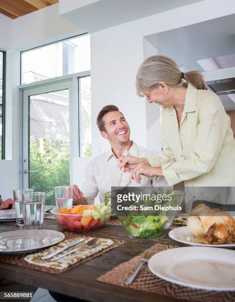 caucasian mother serving son at table - wellness kindness love stock pictures, royalty-free photos & images