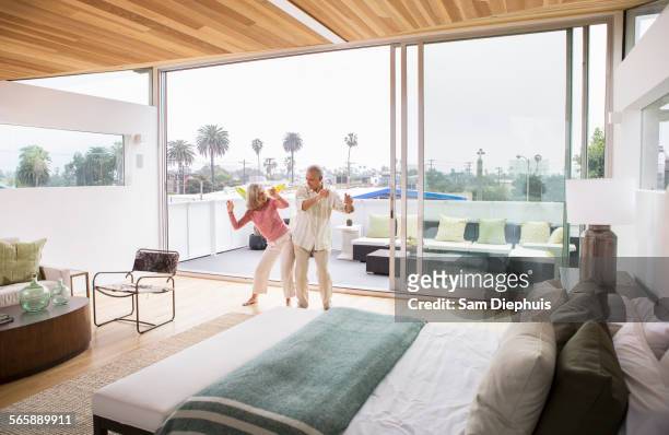 older caucasian couple dancing in bedroom - couple playful bedroom stock-fotos und bilder