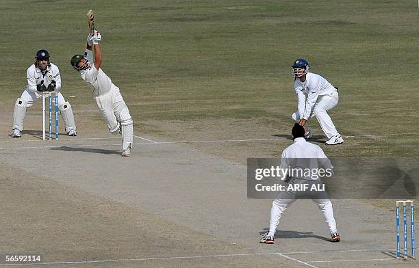 Pakistani batsman Shahid Afridi hits for a six as Indian wicket-keeper Mahendra Singh Dhoni looks on during the second day of the first cricket test...