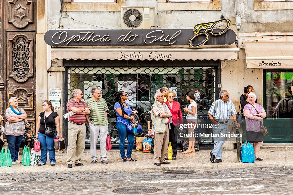 Comutors waiting for bus at optician