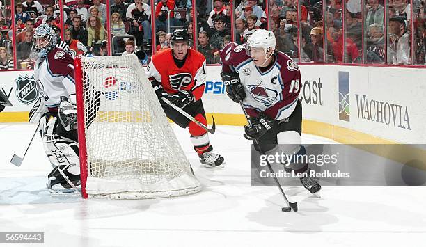 Joe Sakic of the Colorado Avalanche brings the puck out of his zone followed by Mike Richards of the Philadelphia Flyers at the Wachovia Center on...