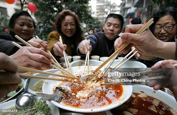Residents dine on a feast to celebrate upcoming Chinese New Year during a community activity on January 14, 2006 in Chengdu of Sichuan Province,...