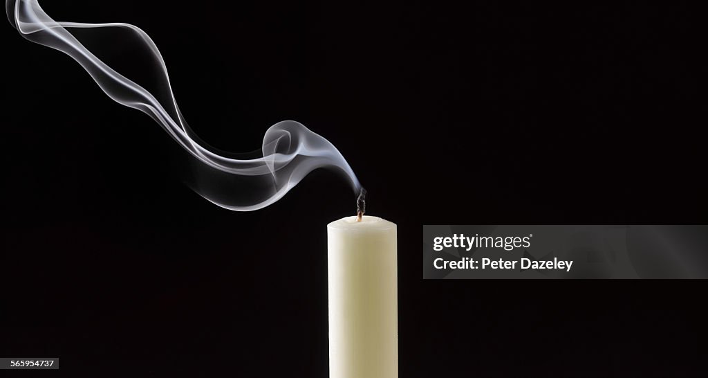 Smoke trailing from extinguished white candle