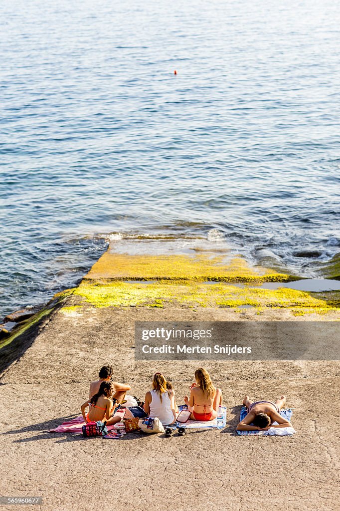 Sunbathers at concrete boat ramp