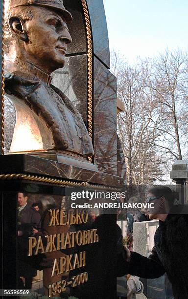 Serbian folk singer Svetlana Raznatovic, the widow of notorious warlord Zeljko Raznatovic-Arkan touches her husband's grave during a memorial service...