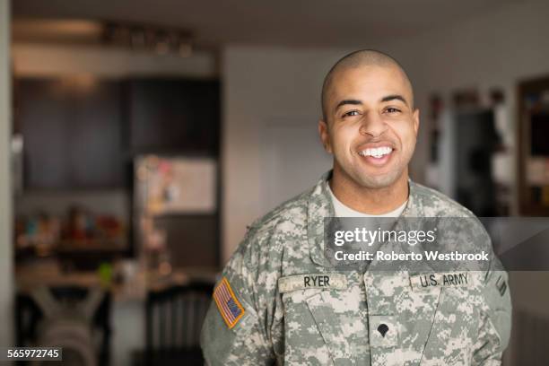 mixed race man smiling in living room - veteran stock-fotos und bilder