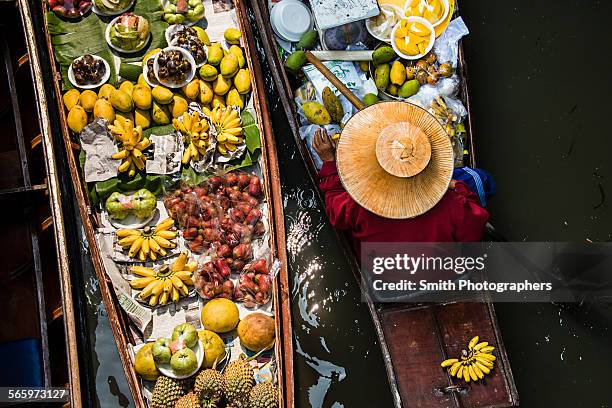 high angle view of merchant selling fruit in canoe - bangkok floating market stock pictures, royalty-free photos & images