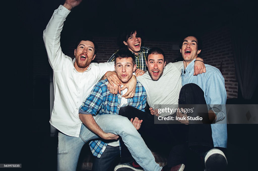 Laughing men playing at party at night