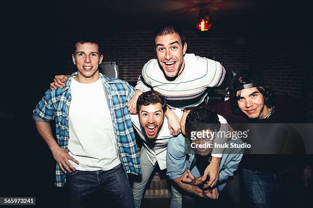 laughing men posing at party at night - five people stock pictures, royalty-free photos & images