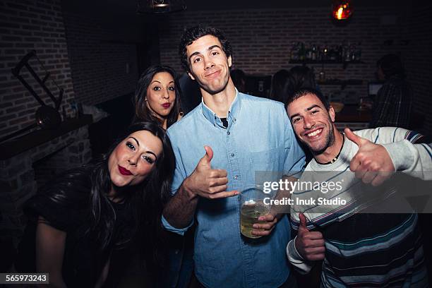 laughing friends giving thumbs up in nightclub - man party night bar posing stock pictures, royalty-free photos & images