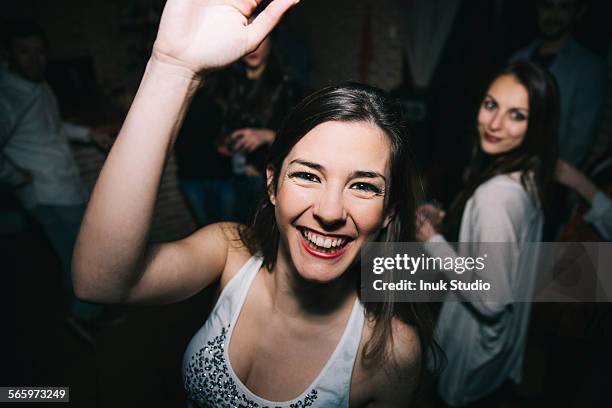 smiling woman waving in nightclub - woman party fotografías e imágenes de stock