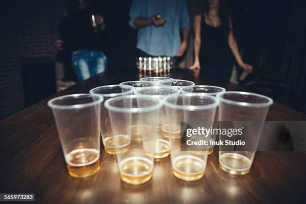 friends playing beer pong at party - beirut stockfoto's en -beelden