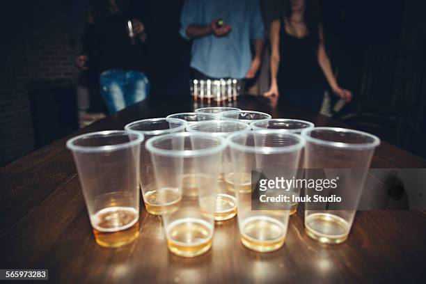 friends playing beer pong at party - beer pong stock pictures, royalty-free photos & images