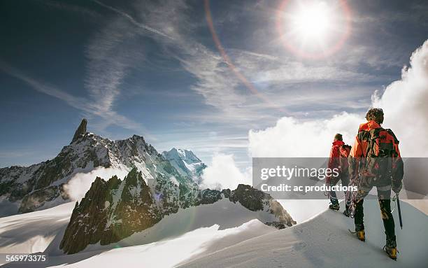 caucasian hikers standing on snowy mountain top, mont blanc, alps, france - aufsteigen stock-fotos und bilder