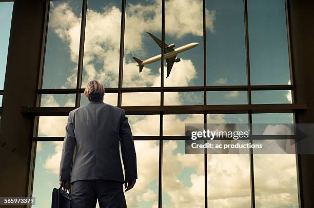 caucasian businessman admiring airplane from airport windows - miami airport stock pictures, royalty-free photos & images