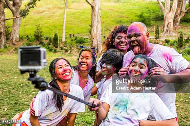 friends covered in pigment powder using selfie stick - paint race stock pictures, royalty-free photos & images