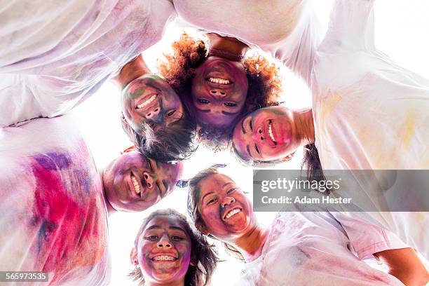 low angle view of smiling friends covered in pigment powder - color run stock-fotos und bilder