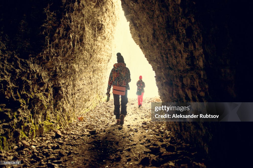 Caucasian hikers walking in rocky cave