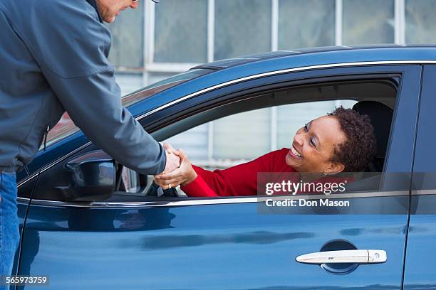 friends shaking hands through car window - road assistance stock pictures, royalty-free photos & images