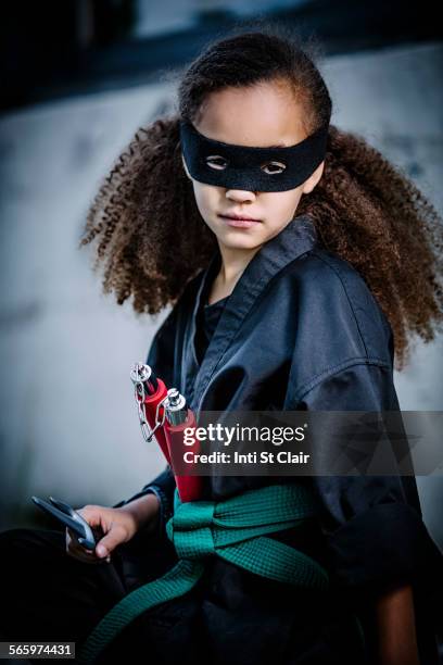 mixed race girl in martial arts uniform and mask - nunchucks stock pictures, royalty-free photos & images