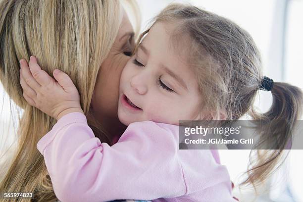 close up of caucasian mother kissing daughter - 面貼面 個照片及圖片檔