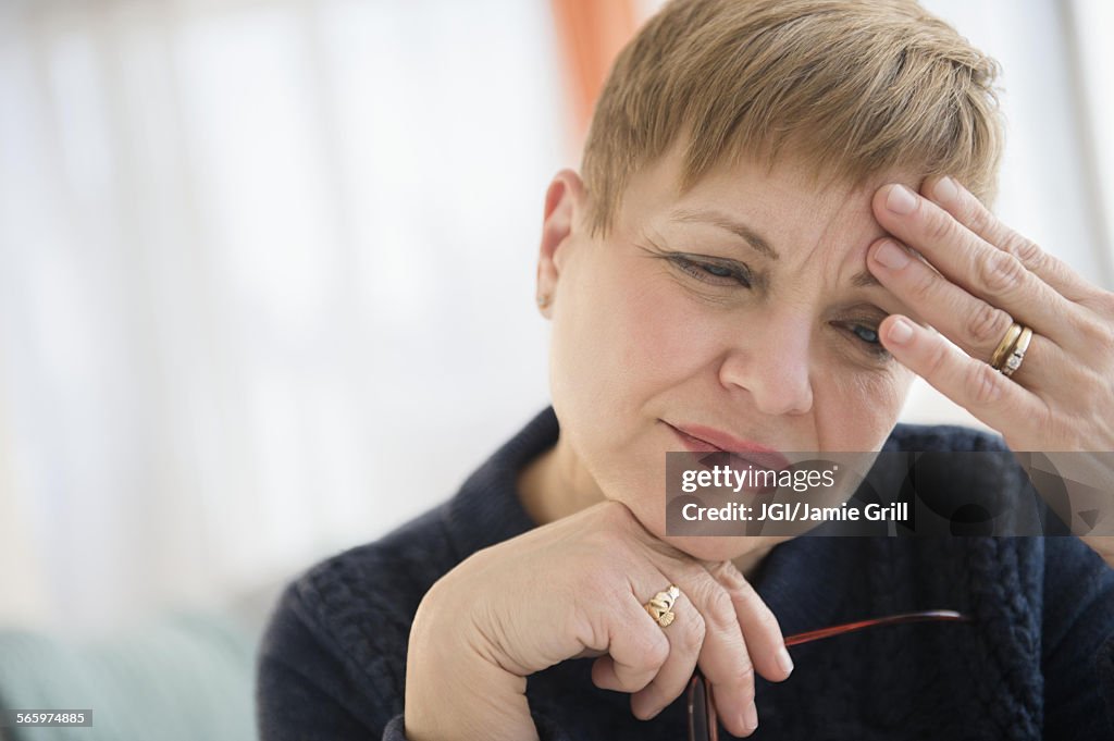 Anxious Caucasian woman rubbing forehead